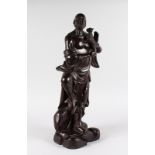 A LARGE HEAVY CARVED CHINESE ROSEWOOD MAN HOLDING A DOG. 2ft 1ins high.