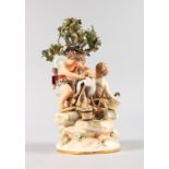 A GOOD MEISSEN GROUP OF TWO CUPIDS sharpening a knife on a wheel beneath a tree. Cross swords mark