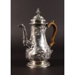 A GEORGE III PEAR SHAPED COFFEE POT with floral repousse decoration and wooden handle. London