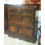 A 17TH CENTURY CARVED OAK CUPBOARD IN TWO PARTS, the upper section with a moulded cornice, a pair of