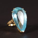 A LARGE AQUAMARINE PEAR SHAPED RING set in yellow gold.