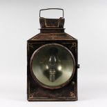 A LARGE BLACK JAPANNED RAILWAY LANTERN with carrying handle, large circular glass fronted door,