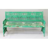 A LARGE GREEN PAINTED VICTORIAN CAST IRON GARDEN SEAT with wooden splats. 5ft 8ins long.