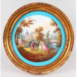 A SUPERB LARGE "SEVRES" CIRCULAR PORCELAIN PLAQUE, painted with figures in a garden setting.