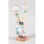 A GOOD MEISSEN TWO BRANCH CANDELABRA, as a classical young lady holding two scrolling branches.