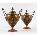 A VERY GOOD PAIR OF REGENCY BRONZE TWO HANDLED URNS AND COVERS, with a panel of cupids holding