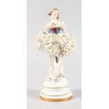 A CONTINENTAL FIGURE OF A BALLERINA, on a circular base. 21cms high.