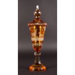 A BOHEMIAN AMBER GOBLET AND COVER, etched with deer in a forest. 15.5ins high.