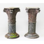 A PAIR OF CARVED WOOD CORINTHIAN COLUMNS, on circular bases. 2ft 7ins high.