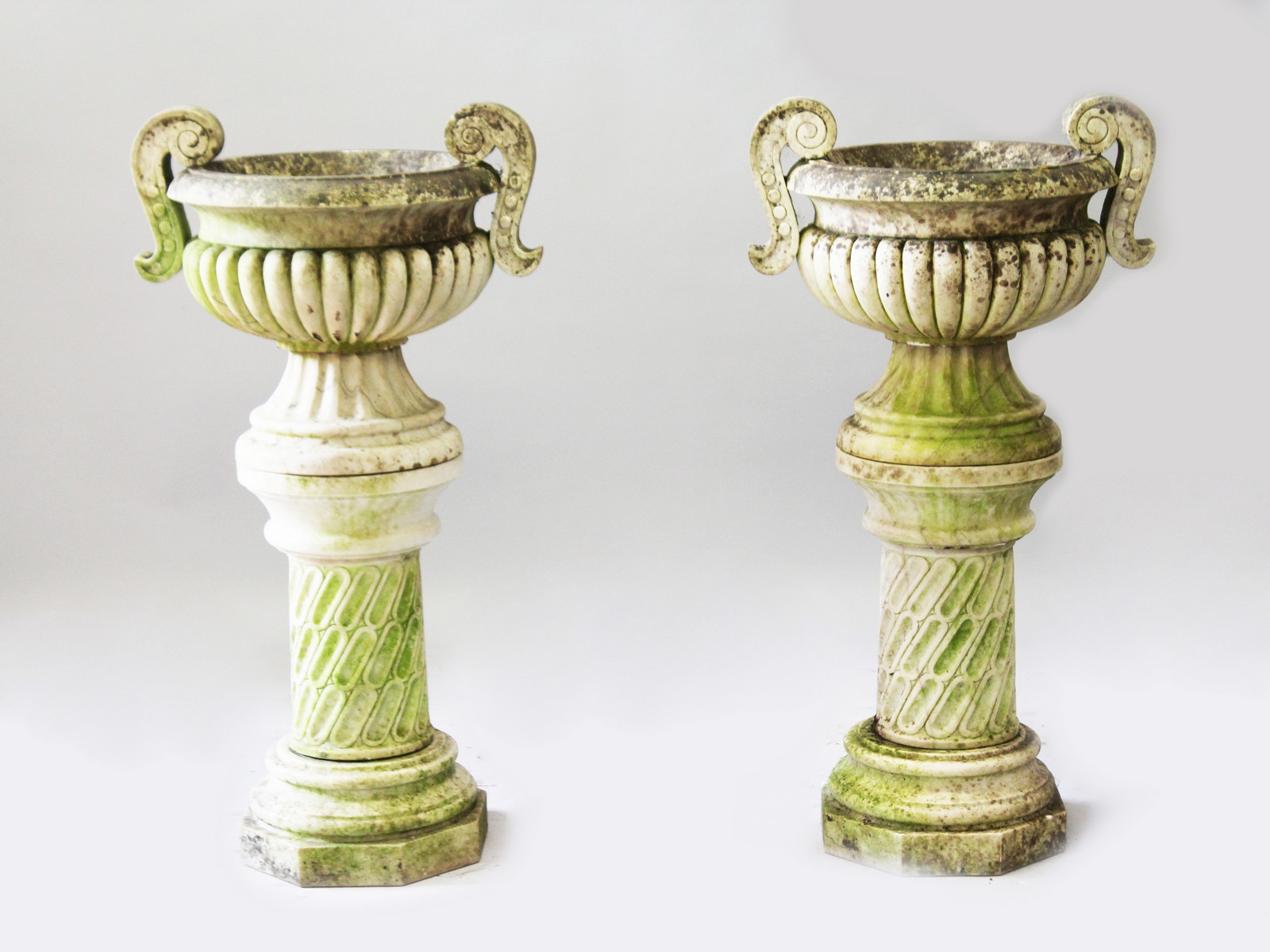 A VERY GOOD PAIR OF CARVED WHITE MARBLE CIRCULAR TWO HANDLED URNS ON STANDS, in the Chinese