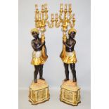 A PAIR OF BLACKAMOOR TORCHERES, 20TH CENTURY, modelled as a pair of boys holding aloft a pair of six