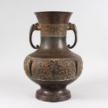 A CHINESE BRONZE ARCHAIC TWO HANDLED BULBOUS VASE with elephant handles. 1ft 4ins high.