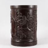 A LARGE HEAVY CARVED CHINESE ROSEWOOD BRUSH POT, carved with figures, buildings, etc. 1ft 3ins high,