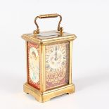 A SMALL BRASS CARRIAGE CLOCK, with red ground panels. 4.25ins high.