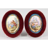 A GOOD PAIR OF SEVRES OVAL PORCELAIN PLAQUES of young lovers. 16cms x 11cms, in velvet frames.