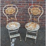 A PAIR OF WHITE PAINTED WROUGHT IRON CHAIRS.