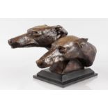 AN ART DECO STYLE BRONZE RESIN GROUP OF TWO DOGS HEADS, mounted on a stepped base. 11ins high.