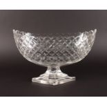 A LARGE HOBNAIL CUT BOTTLE SHAPED FRUIT BOWL on a stepped base. 14ins long.