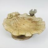 A cast lead bird bath of shell form, surmounted by a bird and sat on a naturalistic base. 15"