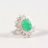 A SUPERB 18CT WHITE GOLD, EMERALD AND DIAMOND CLUSTER RING.