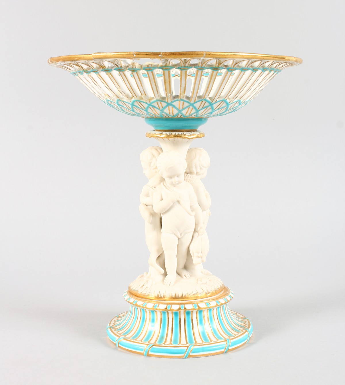 A MINTON CIRCULAR COMPORT, the stem with three bisque cupids. 26cms high.