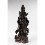 A LARGE CARVED CHINESE ROSEWOOD GUANYIN with flat back. 2ft 6ins long.