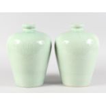 A PAIR OF CHINESE GREEN VASES with incised decoration. 11.5ins high.