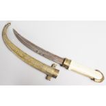 A TURKISH DAGGER with curving blade, bone handle and engraved brass sheath. 15ins long.
