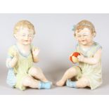 A PAIR OF CONTINENTAL PORCELAIN PAINTED BISQUE SEATED BABIES, the girl holding a ball. 8.5ins high.