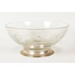 AN ENGRAVED CIRCULAR CUT GLASS FRUIT BOWL with sterling silver base. 9ins diameter.