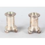 A SMALL PAIR OF TIFFANY SILVER CANDLESTICKS supported on three ball feet. 2.5ins high.