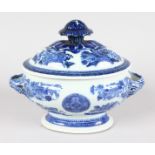 A SMALL BLUE AND WHITE OVAL TUREEN AND COVER with entwined handles. 7ins long.