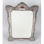 A STERLING SILVER UPRIGHT SHAPED EASEL MIRROR with floral repousse. 13.5ins high, 9.5ins wide.