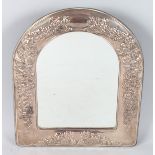 A STERLING SILVER DOME SHAPED EASEL MIRROR, repousse with flowers. 13ins high, 11ins wide.