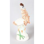 A CONTINENTAL PORCELAIN BIRD by a tree stump. 12ins high.