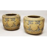 A PAIR OF ITALIAN TERRACOTTA CIRCULAR JARDINIERES with relief decoration, shields and dragons. 1ft