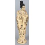 AN EARLY 20TH CENTURY SIGNED JAPANESE MEIJI PERIOD IVORY OKIMONO OF A STANDING LADY, bearing a lotus