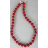 A CHINESE RED CINNABAR LACQUER NECKLACE, with a small oval silver clasp stamped 'Silver', each