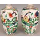 A PAIR OF FAMILLE VERTE PORCELAIN VASES, painted in a Kangxi style with panels of seasonal