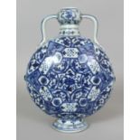 A CHINESE YUAN STYLE BLUE & WHITE PORCELAIN MOON FLASK, decorated with a variety of formal floral