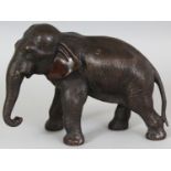 A SIGNED JAPANESE MEIJI PERIOD BRONZE MODEL OF AN ELEPHANT BY SEIYA, the elephant striding forwards,