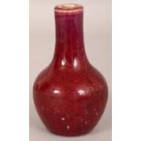 A SMALL 18TH/19TH CENTURY CHINESE FLAMBE BOTTLE VASE, the streaked red glaze turning to purple at