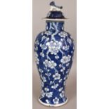 A 19TH CENTURY CHINESE BLUE & WHITE PORCELAIN VASE & COVER, painted with prunus reserved on a