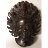 A TIBETAN CARVED WOOD MAHAKALA MASK, the protector with fierce expression and a flame aureole, 10.