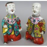 A PAIR OF CHINESE FAMILLE ROSE FIGURES OF KNEELING BOYS, possibly Jiaqing period, each bearing a
