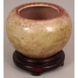 A CHINESE PEACH BLOOM PORCELAIN WATER POT, together with a fitted wood stand, the glaze with