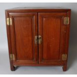 A 19TH/20TH CENTURY CHINESE CARVED HARDWOOD RECTANGULAR CABINET, with bronzed metal fittings and two