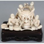 AN UNUSUAL JAPANESE MEIJI PERIOD IVORY OKIMONO OF A GROUP OF MASK MAKERS, unsigned, together with