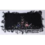 AN EARLY 20TH CENTURY CHINESE CANTON EMBROIDERED BLACK GROUND SILK SHAWL, decorated in vivid colours