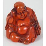 A CHINESE AMBER LIKE CARVING OF A SEATED & SLEEPING BUDAI, the base with an engraved character, 1.
